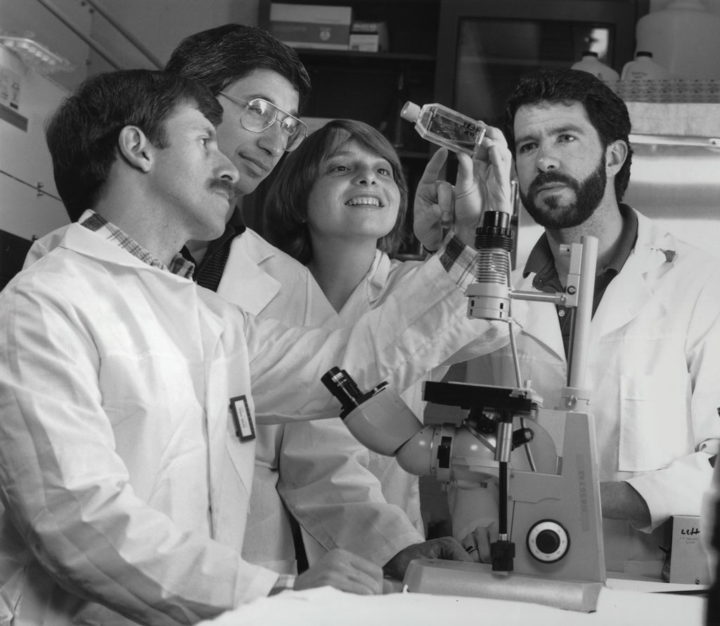 scientists_looking_at_cell_culture_flask